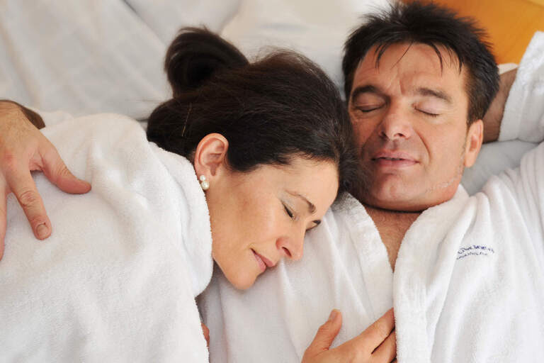 Ein Paar in Wellness-Bademänteln entspannt und genießt die gemeinsame Zeit im Hotel Das Bayerwald
