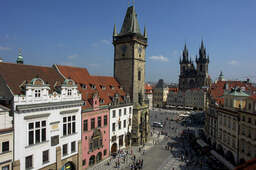 Der Stadtplatz Prags mit einem Uhrenturm und dem Dom im Hintergrund.