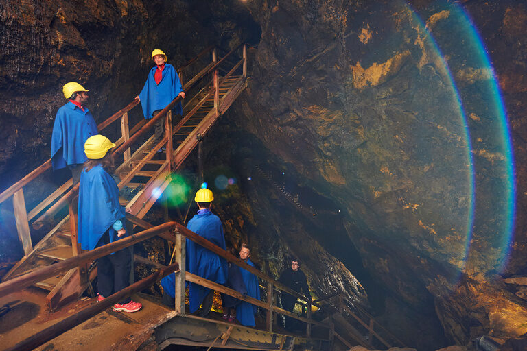Eine Gruppe in Arbeitskleidung steht vor einem Tunnel im Bergwerk Silberberg.